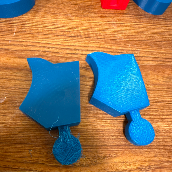 Failed 3D print of toy piece next to successful print