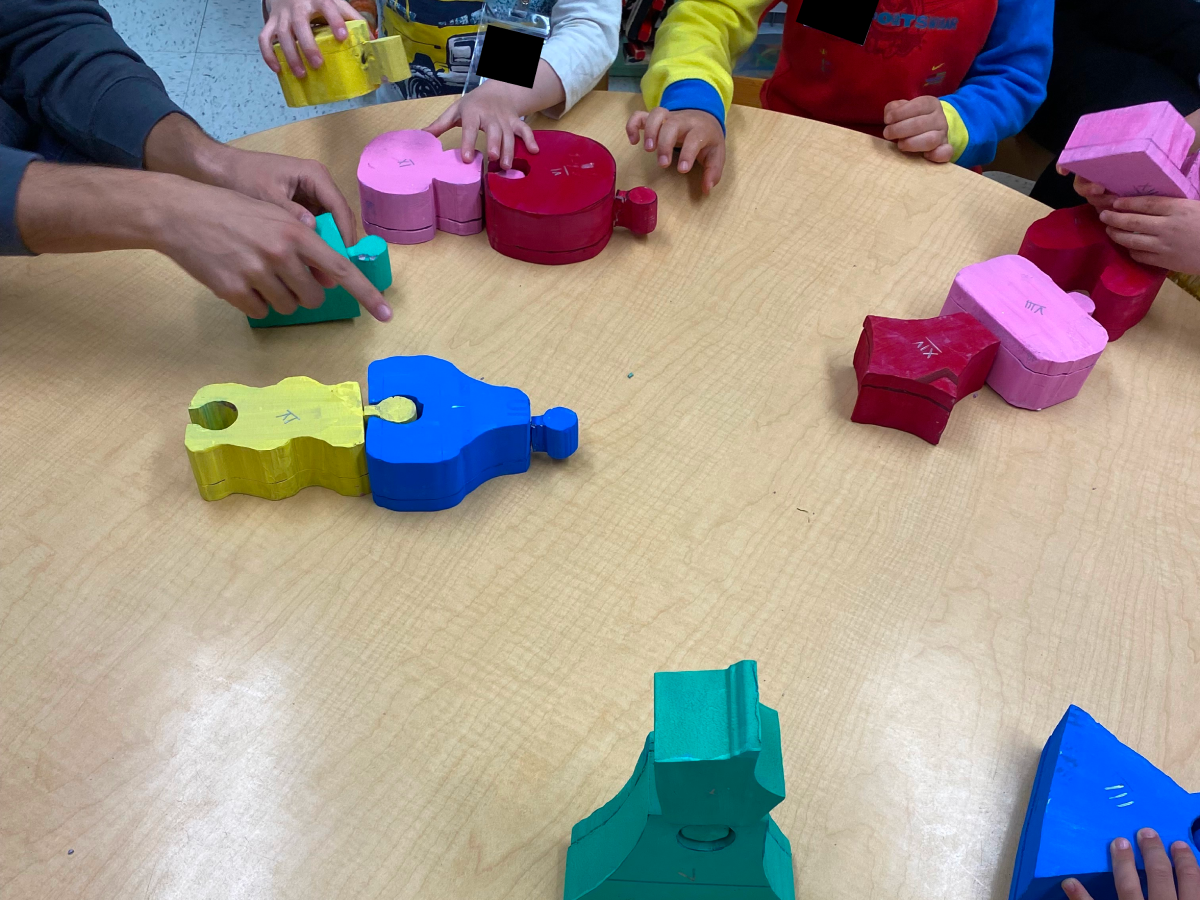 Hands of children playing with colorful foam prototypes in playroom