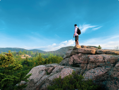 Michael Sezen standing on edge of a rock in Acadia National Park