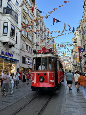 Tram moving on a busy Istanbul street with decorative flags above